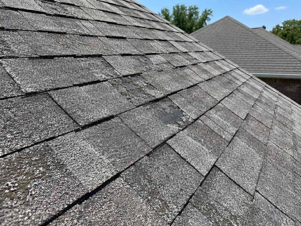 Aging asphalt shingle roof on a Texas home before a metal roof decision